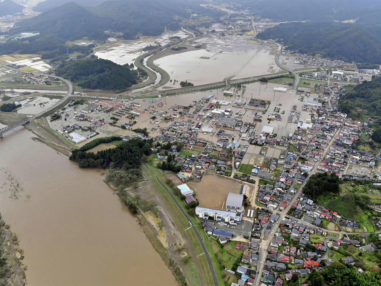 台風19号の影響で浸水し、水に漬かったままの宮城県丸森町。左は阿武隈川＝14日午後０時17分（共同）