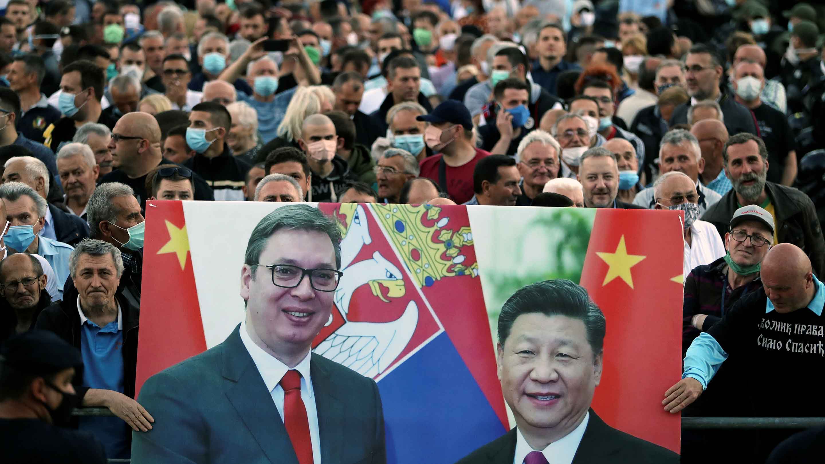 習国家主席とセルビアのアレクサンダル・ブチッチ大統領の写真を掲げる同国政府の支持者ら（2020年5月）