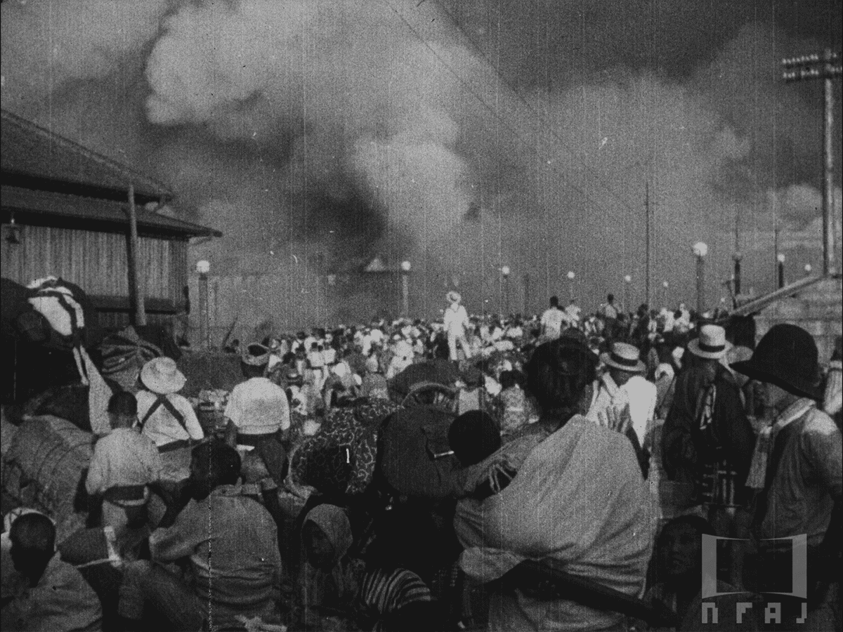 隅田川にかかる吾妻橋の西詰めから対岸の火災をみる人々